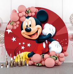 a mickey mouse birthday party with balloons and streamers