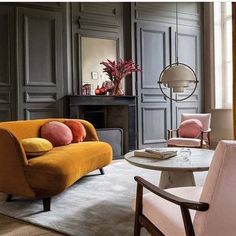 a living room filled with furniture and a fire place next to a mirror on the wall