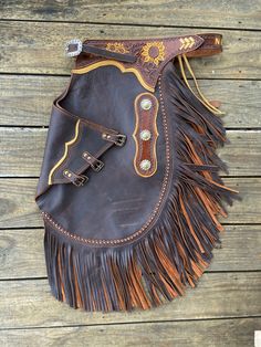 a brown leather bag with fringes on it