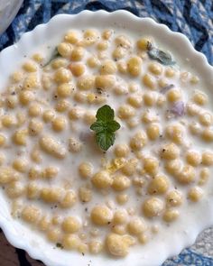 a white bowl filled with macaroni and cheese on top of a blue table cloth