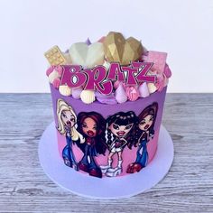 a birthday cake decorated with the name braz and three girls on it's side