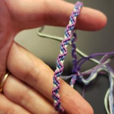 a person holding a piece of yarn in their left hand and the other end of the string