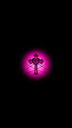 a cross in the middle of a dark room with pink light on it's side