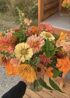 a vase filled with lots of different colored flowers