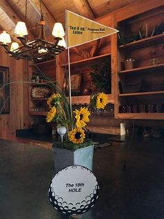 a vase with sunflowers in it sitting on a table next to a sign that says the 19th hole