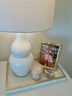 a table with a lamp, photo and other items on it