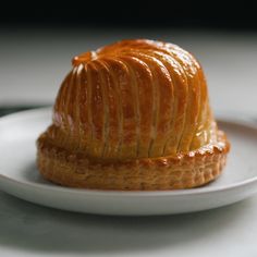 a pastry on a white plate with sauce drizzled over it's top