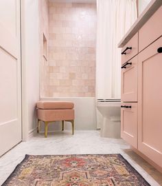 a bath room with a toilet and a rug