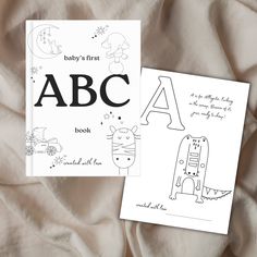 two children's books are laying on a bed with the letters abc and h