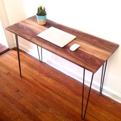 a wooden table with hairpin legs and a laptop on it