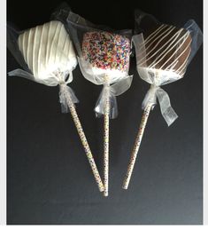 three candy lollipops wrapped in cellophane and sprinkles