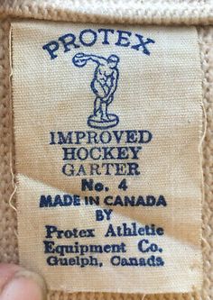 a label on the back of a jacket that says,'protect hockey garter made in canada '