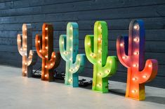 three large neon cactus lights are next to each other