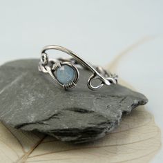 A silver and aquamarine ring with a twist and open spiral design. It's adjustable and perfect as a gift if you're not quite sure of the size you need. The shank is twisted from one wire and in the loop at the end is nestled a round faceted aquamarine bead. This version is milky which highlights the colour wonderfully and reminds me of frozen lakes and ice skating. Versions with a clear aquamarine and with moss aquamarine are also available in my shop. The opposite end from the gem is shaped into Adjustable Aquamarine Gemstone Rings, Adjustable Silver Blue Topaz Jewelry, Adjustable Aquamarine Jewelry As Gift, Adjustable Blue Topaz Birthstone Jewelry, Adjustable Birthstone Jewelry With Blue Topaz, Viking Jewellery, Moss Aquamarine, Viking Ring, Braided Ring