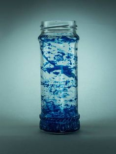 a blue and white glass jar sitting on top of a table