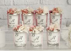 six jars with flowers in them sitting on a shelf