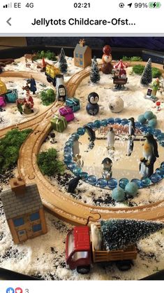 a toy train set is on display in a store window with fake snow around it