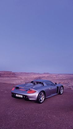 a silver sports car parked in the desert