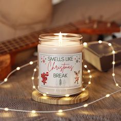 a candle that is sitting on a table next to some string lights and a guitar