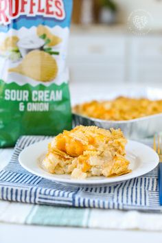 a white plate topped with macaroni and cheese next to a bag of chips