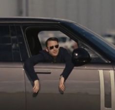 a man in sunglasses leaning out the window of a car