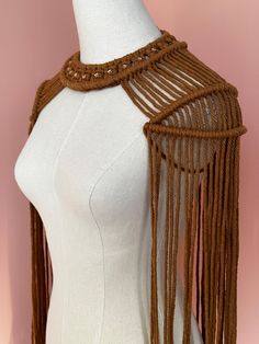 a white mannequin with brown fringes on it