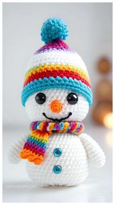 a crocheted snowman with a colorful hat and scarf