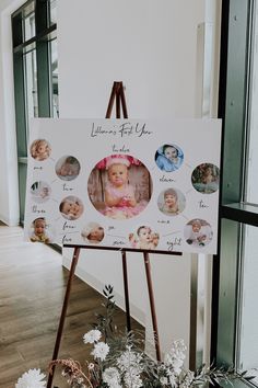 an easel with a baby's first year photo on it next to flowers