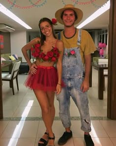 a man and woman standing next to each other in front of a mirror with flowers on it