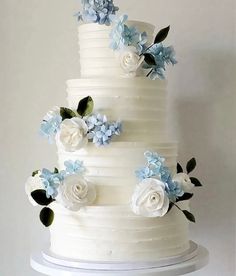 a white wedding cake with blue and white flowers