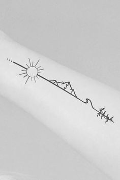 a person with a tattoo on their arm that has the sun and mountains in it