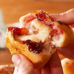 someone is holding up a pastry with jelly on it