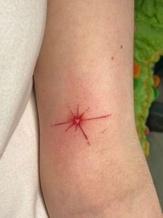 a person with a red star tattoo on their arm