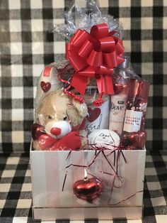 a teddy bear in a gift box on a checkered tablecloth