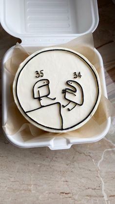 a cake in a box with two faces drawn on it