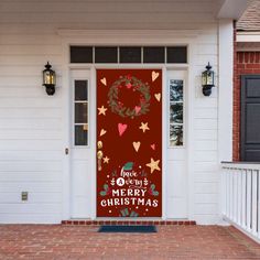 a red door with a merry christmas sign on it's side and wreath hanging from the front