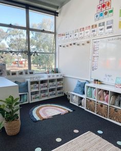 a room with lots of whiteboard and baskets on the floor in front of large windows