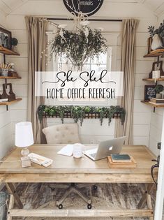 a wooden table with a laptop on top of it in front of a window filled with potted plants