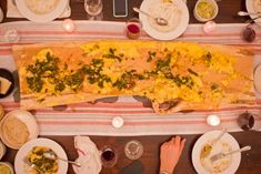 an overhead view of food and wine on a table with people sitting at it,