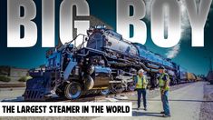 two men standing in front of a train with the words, big boy on it