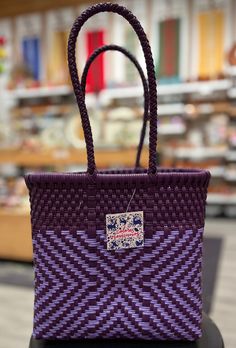 Tough, cute, and eco-friendly, these bags are great for everyday use! Handwoven from recycled plastic, every pattern is unique. Some are even accompanied by a vibrant, handmade pom-pom/heart ornament! Measurements are formatted: L x W x H in inches. Handmade in Oaxaca, México. Casual Purple Woven Bag, Eco-friendly Woven Bag For Gift, Purple Handwoven Rectangular Bag, Rectangular Purple Handwoven Bag, Traditional Purple Rectangular Bag, Purple Woven Rectangular Bag, Purple Handwoven Bags For Daily Use, Purple Handwoven Bag For Everyday Use, Fair Trade Rectangular Gift Bags