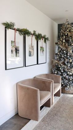 a living room with a christmas tree and two chairs