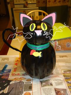 a black cat figurine sitting on top of a table