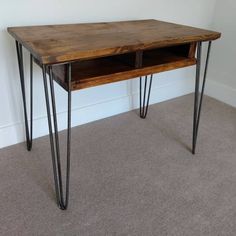 a wooden table with hairpin legs and a shelf on the top that has two open compartments