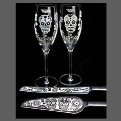 two wine glasses sitting next to each other on top of a black surface with a knife and fork