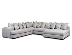 a large sectional couch with many pillows on the top and bottom corner, in light gray fabric