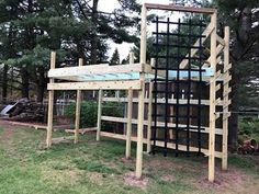 a wooden structure sitting on top of a lush green field