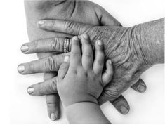 black and white photo of an adult holding the hand of a child's hand