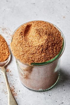 there is a spoon next to a jar with some brown stuff in it