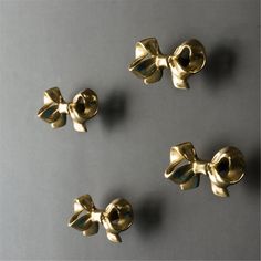 four gold bowknots on a gray surface